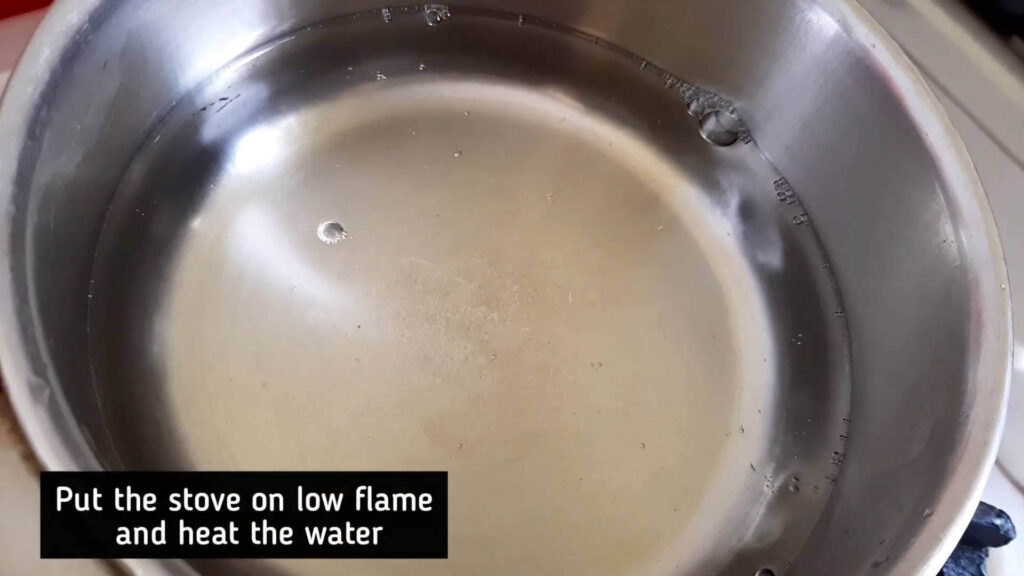 Put the stove on low flame and heat the water